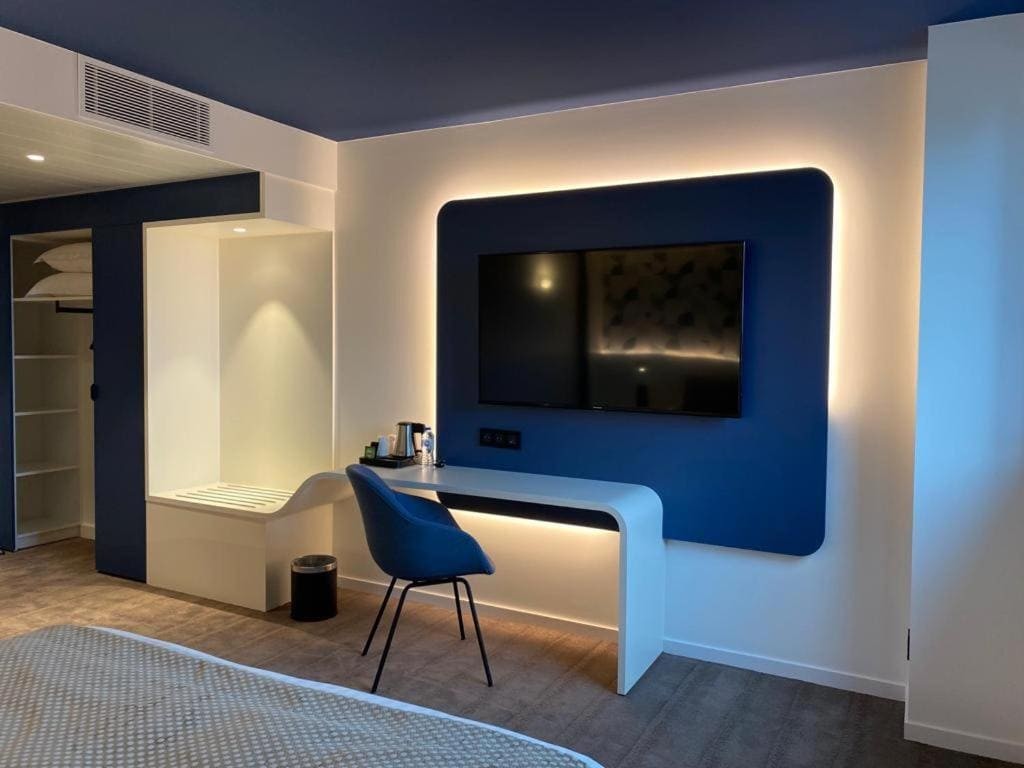 Chambre d'hôtel moderne avec bureau et télévision, conçue par JoyDesign Intérieur pour le Brit Hôtel.