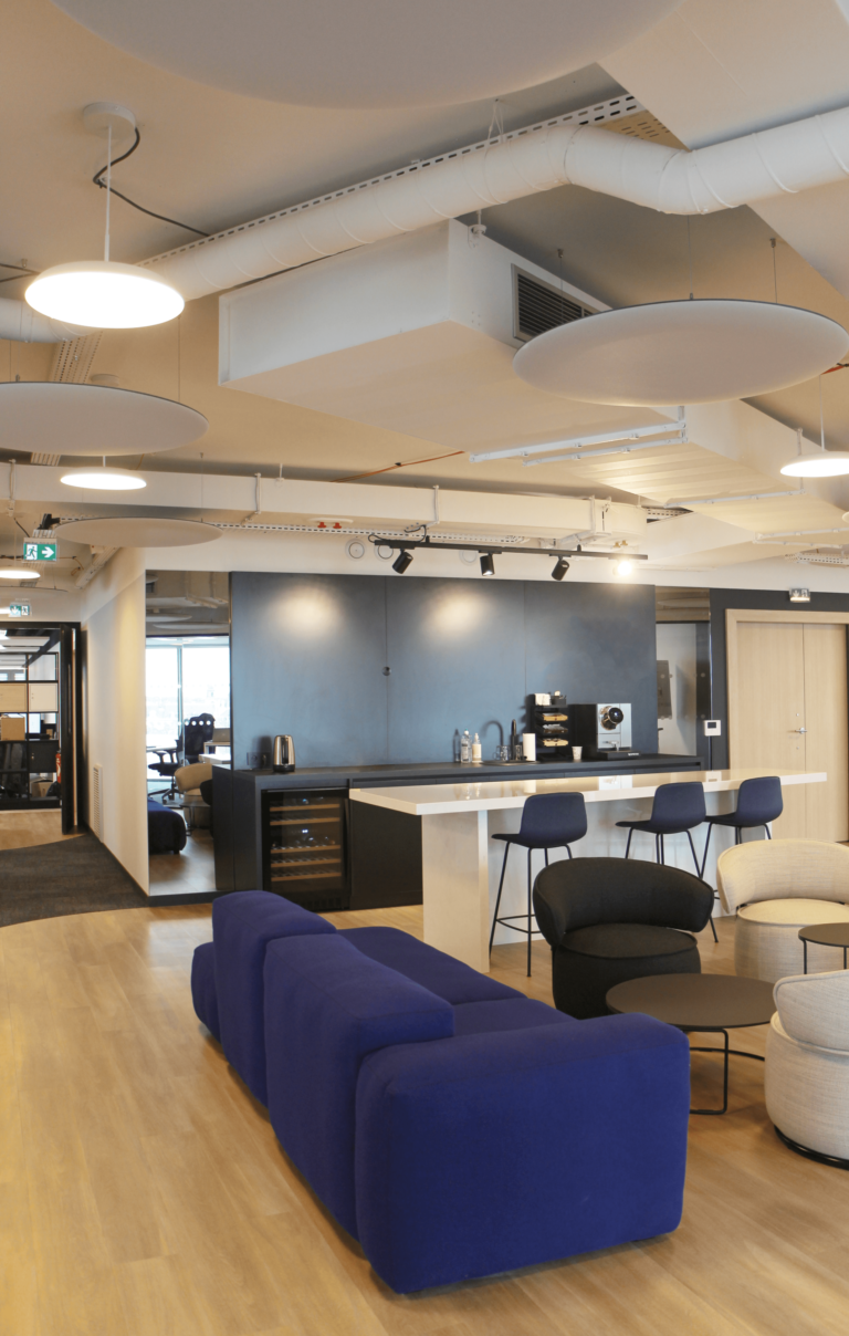 Espace de détente et cuisine moderne dans des bureaux conçus par JoyDesign Intérieur, avec le bleu au cœur du design, situés dans l’hypercentre de Rennes.