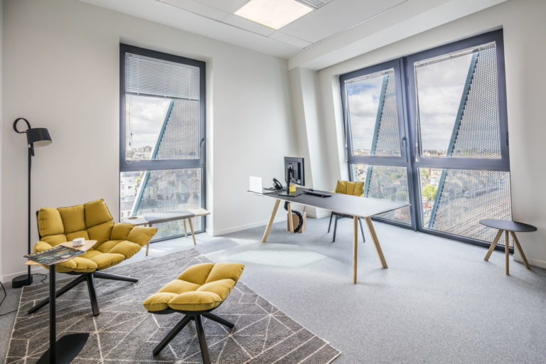 Bureau individuel lumineux avec fauteuils jaunes et grande fenêtre, conçu par JoyDesign Intérieur.