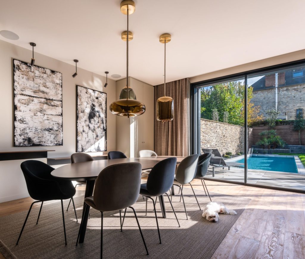 Salle à manger luxueuse avec vue sur la piscine dans une maison mitoyenne.