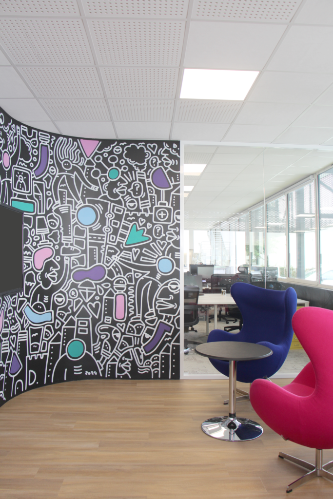 Espace détente avec mur graphique et fauteuils colorés.