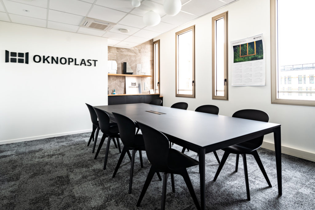 Salle de réunion élégante et lumineuse avec mobilier noir.